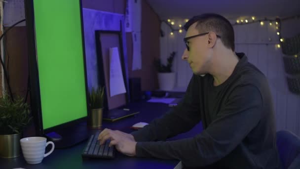남자는 컴퓨터 앉아서 파란색 뒤에서 하거나 게임을 합니다 남자는 프리랜서로 — 비디오
