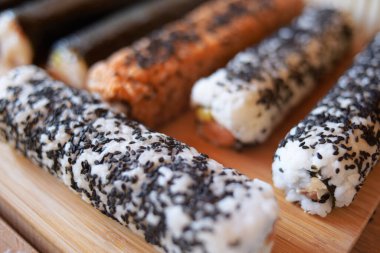 Kesilmemiş hazır suşi bütündür. Kendi ellerimizle pişiririz, nori, karides, balık, bir sürü susam. Mat, Norveç yosunları için pansiyon.