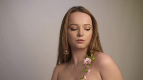 肖像画 ピンクの花 芽を持つ美しいモデルの女の子 少女は春の初めを継承する 花や春をイメージした繊細なピンクのメイク — ストック動画