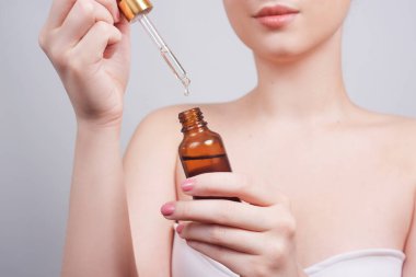 Masaj terapisti spa salonundaki kadının eline spa yağı döküyor. El ele tutuşuyor, pipet düşürüyor, ilaç pipeti bırakıyor. Kız eli