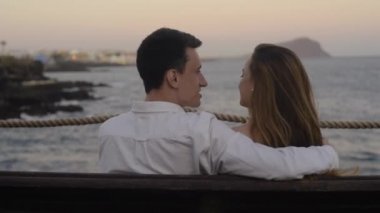 Bir çift tatilde okyanus ve dağların arka planında bir bankta oturuyor. Sevgi dolu bir çift kucaklaşır ve konuşur. Uzağa bakar ve doğayı inceler. Balayı gezisi, düğün.