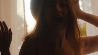 Yazın şapkalı güzel, uzun saçlı bir kız beyaz perdelerle pencereye doğru yürür, dans eder, flört eder, seyahat eder. Sıcak bir sabah, manken pozu, günbatımında şık bir kız, yaz