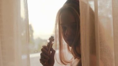 Yazın güzel, uzun saçlı bir kız gün batımını izlemeye gider. Kız sigara içiyor, model vapit vape, elektronik sigaradan bir sürü duman çıkıyor.