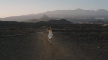Beyaz uzun elbiseli bir kız yolculuğa çıkar, dans eder, doğanın ve özgürlüğün tadını çıkarır. Dağlarda gün batımına karşı uzun saçlı güzellik. Adaların güzelliği