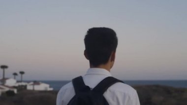 Adadaki dağlarda sırt çantalı bir gezgin. Beyazlı bir adam özgürlüğün kokusunu içine çeker, doğayla bütünleşir. Arka planda Gece Şehri. Adam kameraya gülümsüyor.