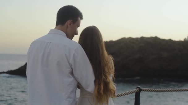 여행을 사랑하는 부부는 바다와 오지에서 껴안고 키스하고 이야기하고 하늘을 쳐다보고 — 비디오