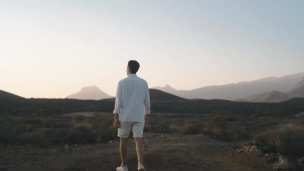 Man Vita Kläder Promenerar Längs Sommarö Solnedgången Resenär Vandrar Bergen — Stockvideo