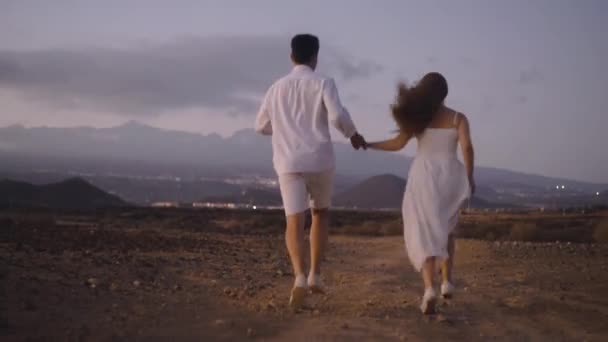 Casal Brancos Corre Pela Ilha Noite Amantes Contexto Montanhas Durante — Vídeo de Stock