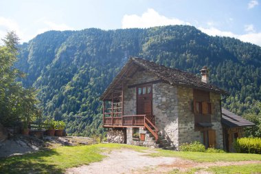 Stone chalet in mountain landscape, Italy. clipart