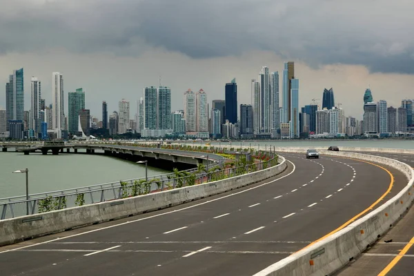 Bulutlu bir günde ön planda dış yol ile Panama şehir manzarası.
