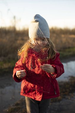 Ellerinde ince bir buz parçası tutan çocuk, vücudunu kapatıyor.