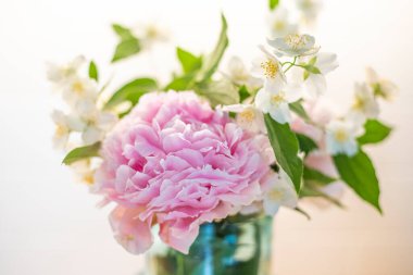 Şakayıklı çiçek buketi (peeonia) ve alay portakalı (philadelphus), bahar bitkileri. Pembe ve beyaz arkaplan, yakın plan..