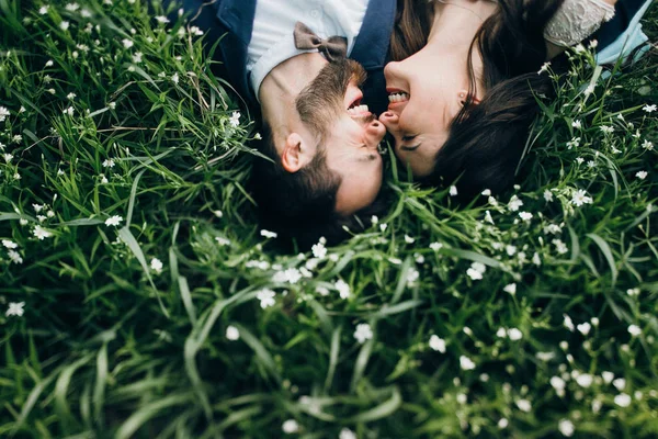 Vista Aérea Pareja Joven Sonriendo Tendida Campo Con Flores Silvestres — Foto de Stock