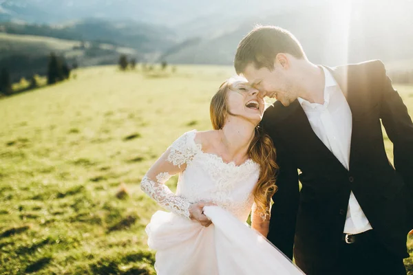 Pengantin Baru Tertawa Sambil Berjalan Oleh Lapangan Musim Semi — Stok Foto