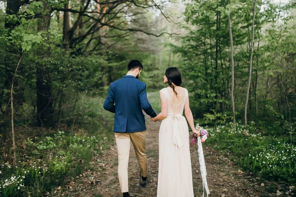 Back view of young couple walking in forest