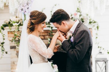 poz yeni evli genç çift. damat öpüşme gelinin el