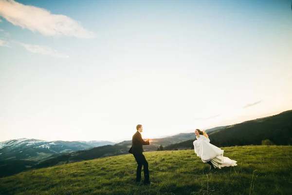山のポーズ新婚の若いカップル 花嫁の新郎に実行しています — ストック写真