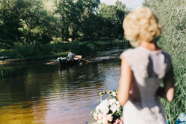 若い花嫁銀行湖とボートで漕ぎ新郎 — ストック写真