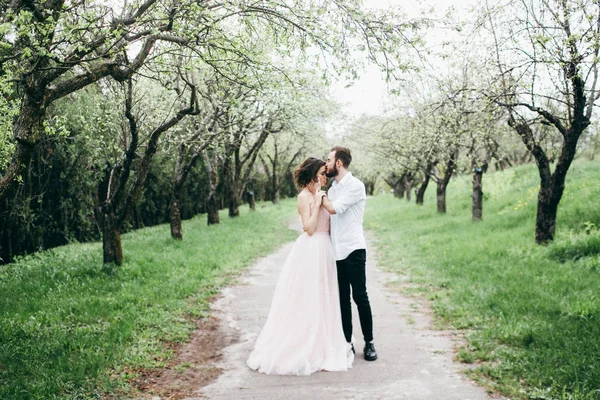 若いカップル新婚夫婦でキスの春の庭 — ストック写真