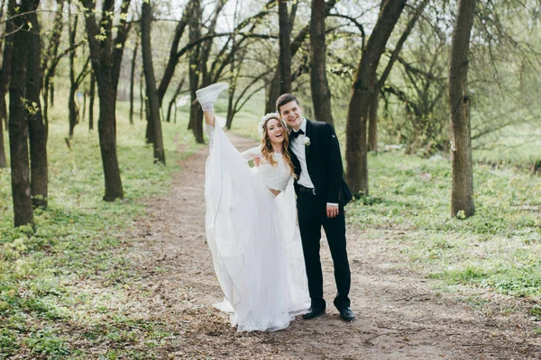 Pareja Joven Recién Casados Posando Hermoso Jardín Novia Mostrando Zapato —  Fotos de Stock