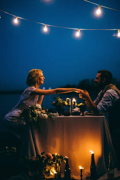 iskelede akşam yemeği yeni evli mutlu genç birkaç. Damat öpüşme gelinin el