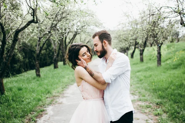 年轻夫妇的情侣拥抱在春季花园 — 图库照片
