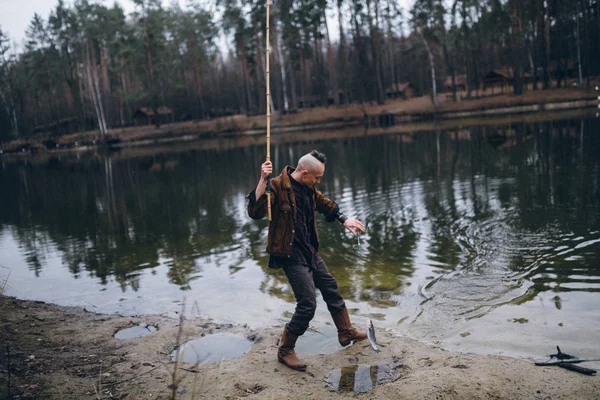 ハンサムな漁師は湖で彼を捕まえると — ストック写真
