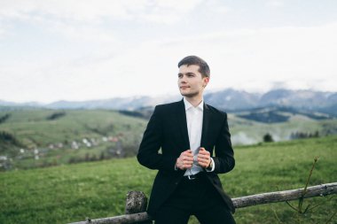 yakışıklı genç damat dağlarda poz