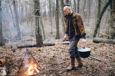 genç adam ormanda sonbaharda yemek 