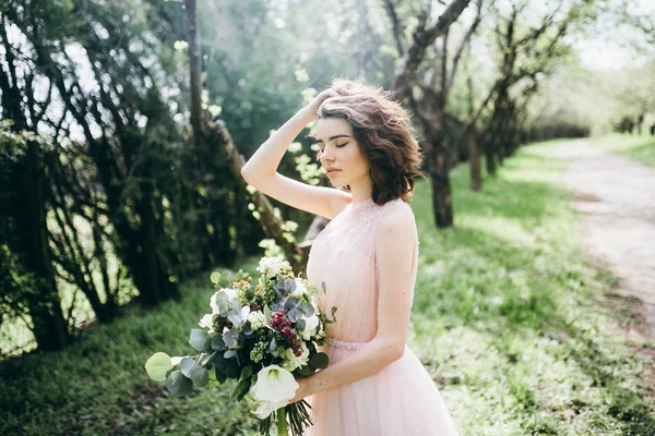 屋外の花を保持若い美しい花嫁 — ストック写真