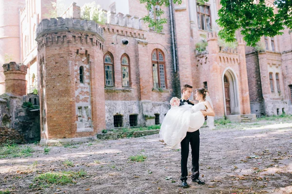 Casamento Casal Posando Perto Velho Castelo Incrível Noivo Segurando Noiva — Fotografia de Stock