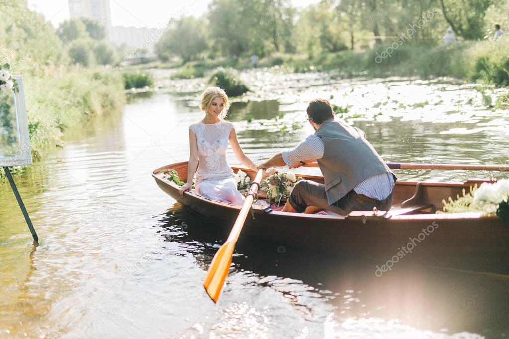 young wedding couple in boat. man rowing