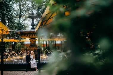 Çeşme tarafından şehirde poz genç güzel Çift