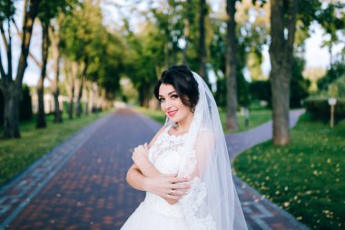 Genç güzel gelin dışarıda poz veriyor.