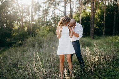 Güzel genç çift yaz Park. Öpüşme kadının omuz ahbap 