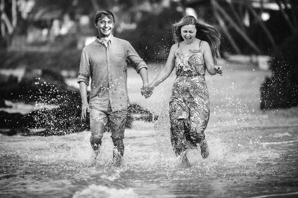 幸せな若いカップル スリランカの休日に水を実行します — ストック写真