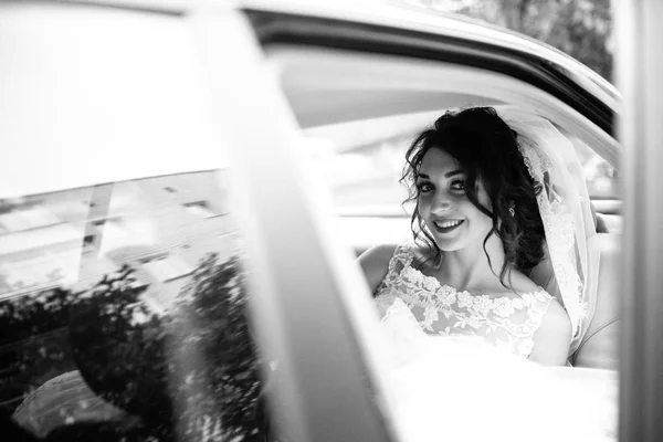 年轻美丽的新娘摆在车上 — 图库照片