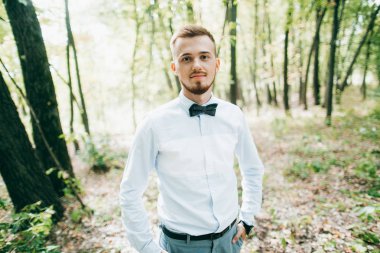 yakışıklı genç damat parkta poz