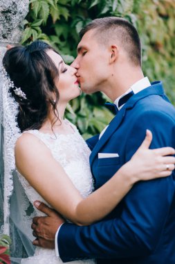 Güzel, genç bir çift yeni evli ve öpüşüyor. 