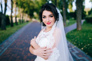 Genç güzel gelin dışarıda poz veriyor.