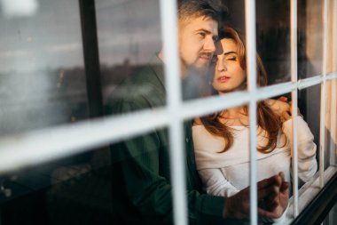 genç güzel çift kapalı poz. Pencereden görüntüleme 