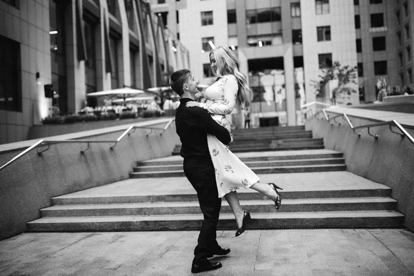 young beautiful couple posing in  city. man holding woman in arms