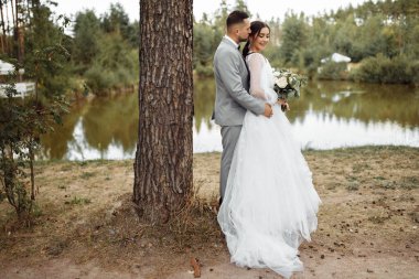 Ormanda kucaklaşan mutlu genç çiftler.