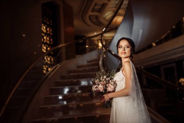 İçeride poz veren mutlu, genç gelin.