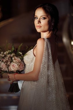 Çiçeklerle poz veren mutlu güzel gelin 