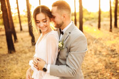 Ormanda kucaklaşan mutlu genç çiftler.