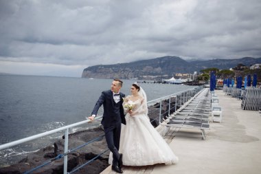 Deniz kıyısında mutlu genç gelin ve damat