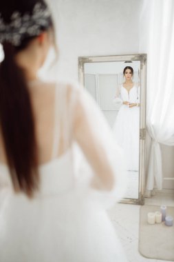 Mutlu, güzel, genç gelin aynanın önünde. 