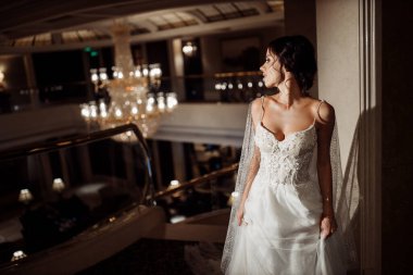 İçeride poz veren mutlu, genç gelin.