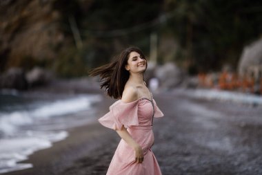 Deniz kenarında poz veren mutlu güzel gelin